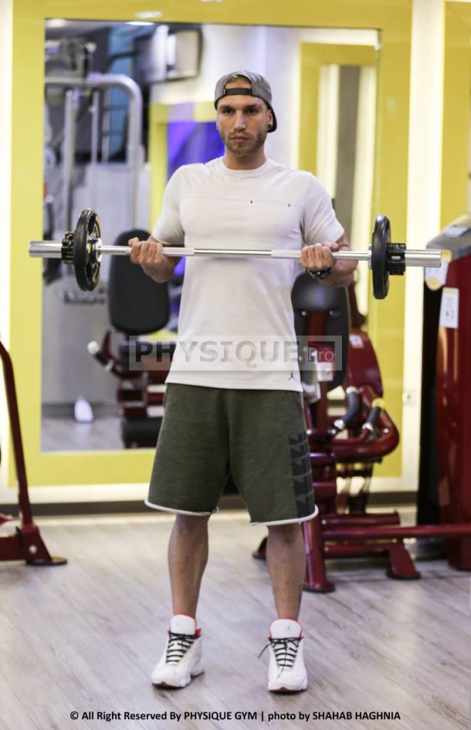 آموزش حرکت جلو بازو هالتر ایستاده آرنج به عقب